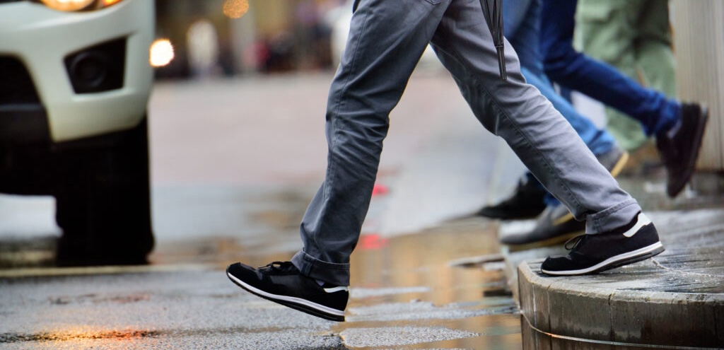 pedestrian accident attorney, image of wet sidewalk crossing with people