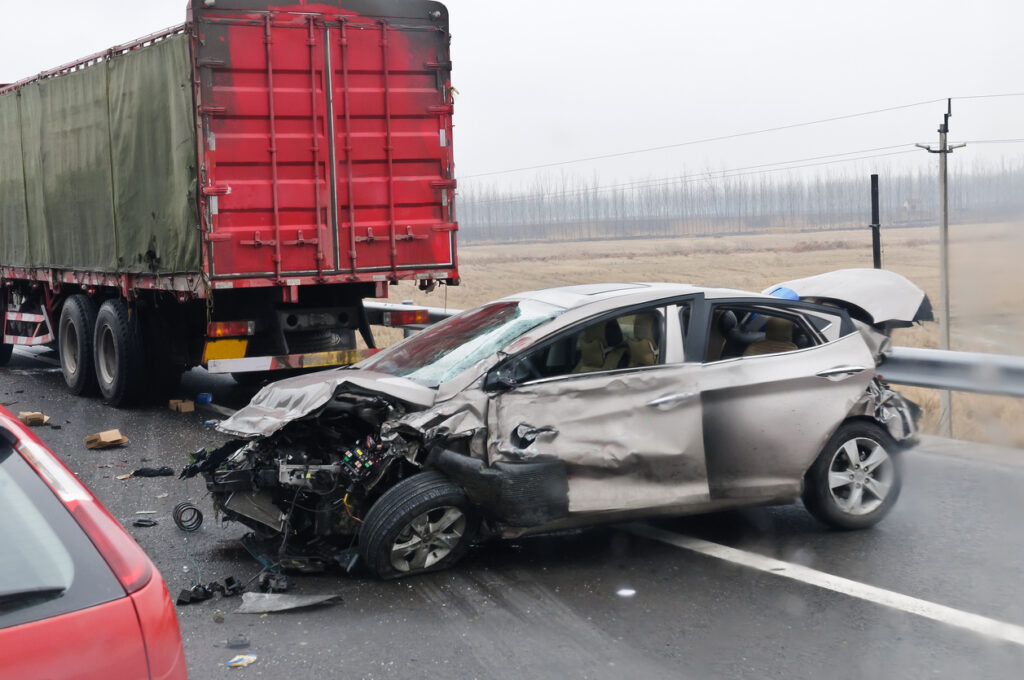 Damaged car behind semi-truck accident investigation