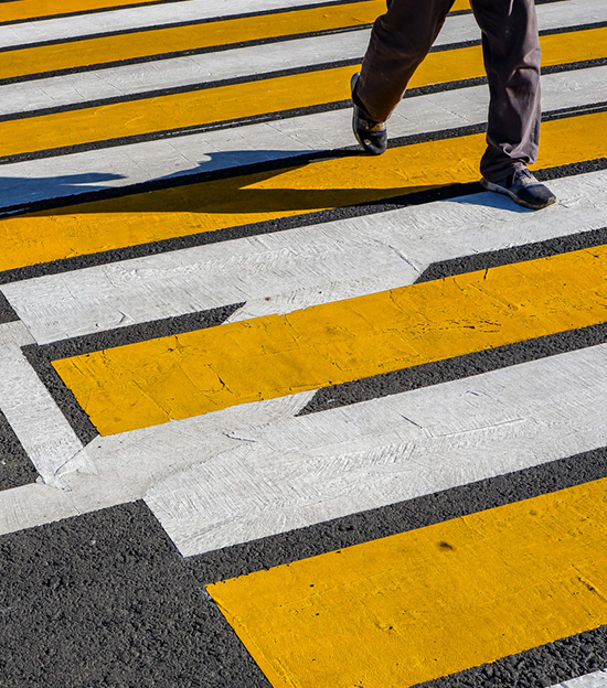 person walking across sunny crosswalk, personal injury attorney at chain law will help with any pedestrian accidents